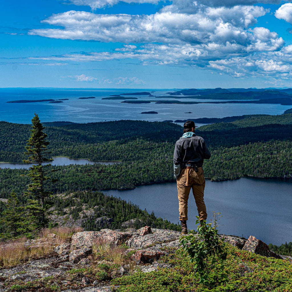 Outdoorsman standing on a bluff overlooking the water