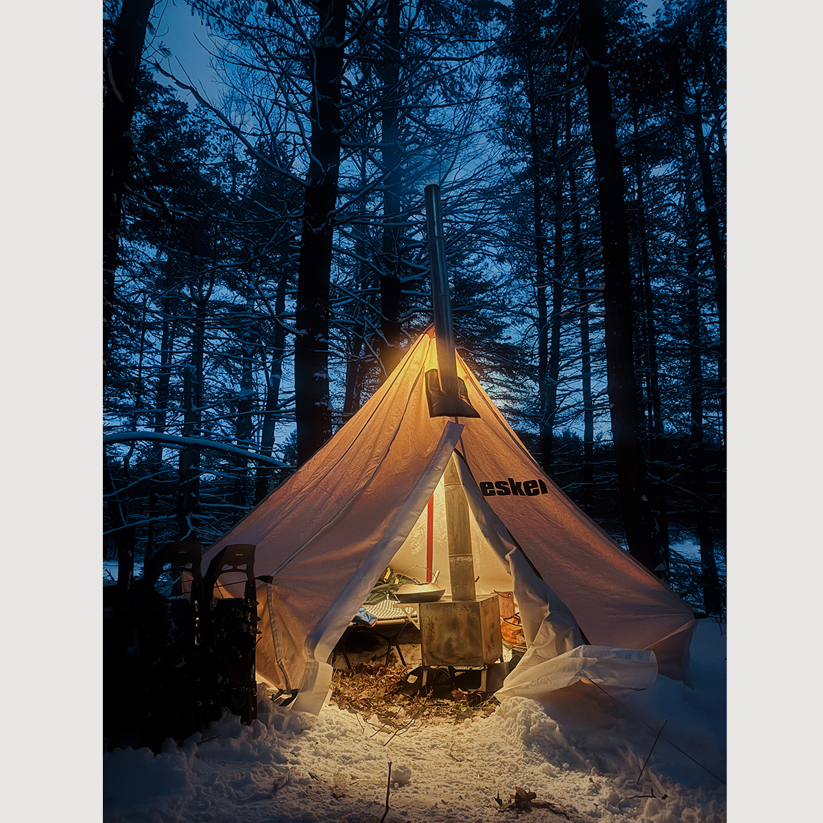 a glowing esker tent in a snowy forest