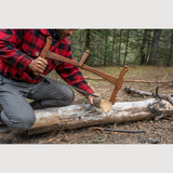 a person using an esker bucksaw to cut wood 