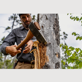 Person using an esker camp axe to chop a tree in a forest 