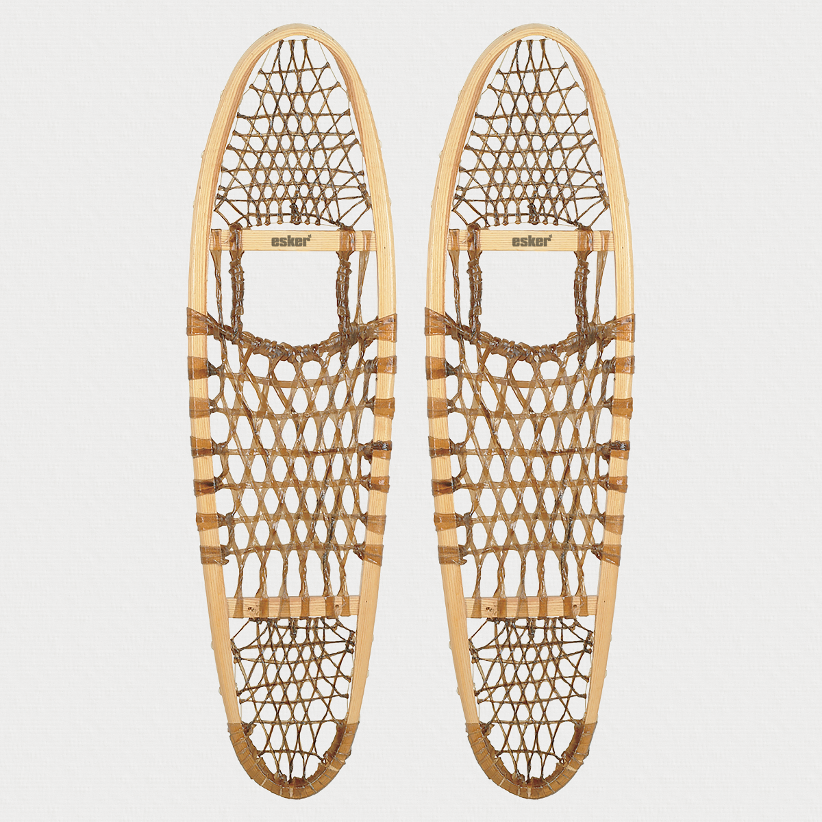 Pair of traditional snowshoes on a light grey background 
