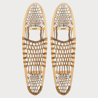 Pair of traditional snowshoes on a light grey background 