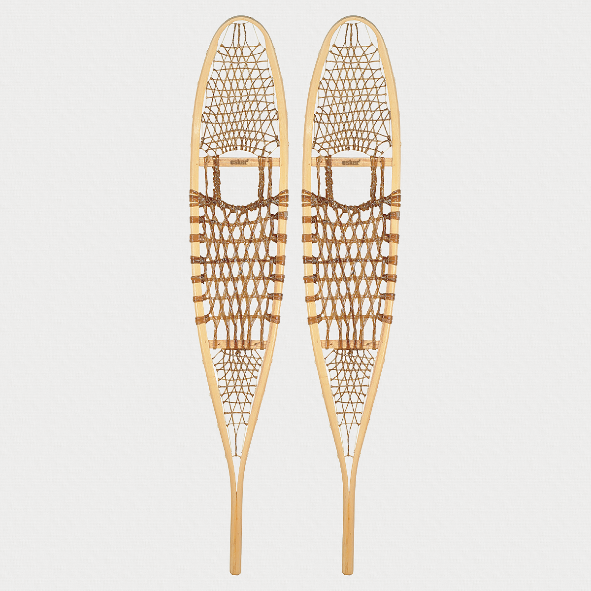 Pair of traditional snowshoes on a light grey background 