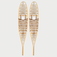 Pair of traditional snowshoes on a light grey background 