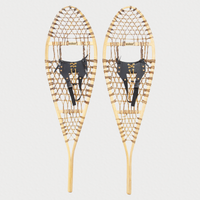 Pair of traditional snowshoes, with leather bindings on a light grey background 